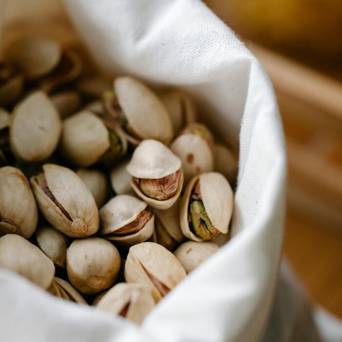 A high-angle view of organic pistachios in a reusable cotton bag, promoting zero waste.